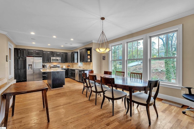 dining space with baseboards, light wood-type flooring, and ornamental molding
