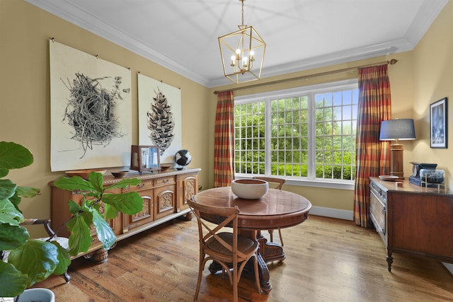 dining space featuring an inviting chandelier, baseboards, ornamental molding, and wood finished floors