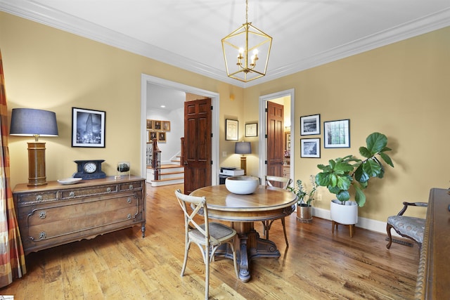 dining room featuring stairway, an inviting chandelier, ornamental molding, and wood finished floors