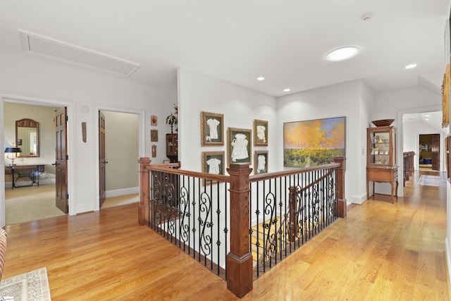 corridor featuring recessed lighting, an upstairs landing, attic access, and wood finished floors