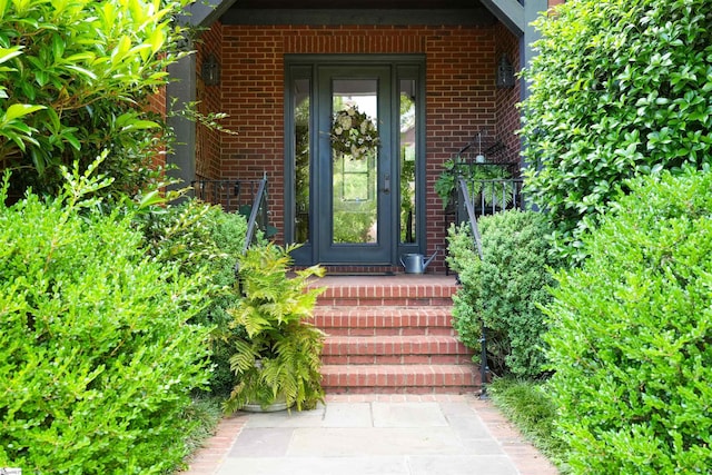 doorway to property featuring brick siding