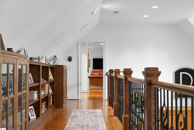 hall featuring baseboards, vaulted ceiling, recessed lighting, visible vents, and wood finished floors