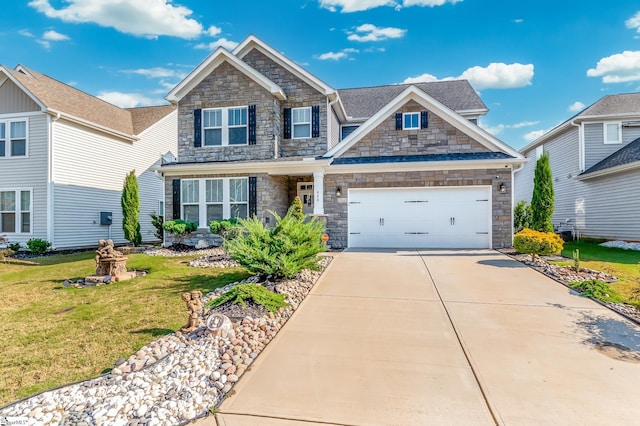 craftsman-style house featuring concrete driveway, an attached garage, stone siding, and a front lawn