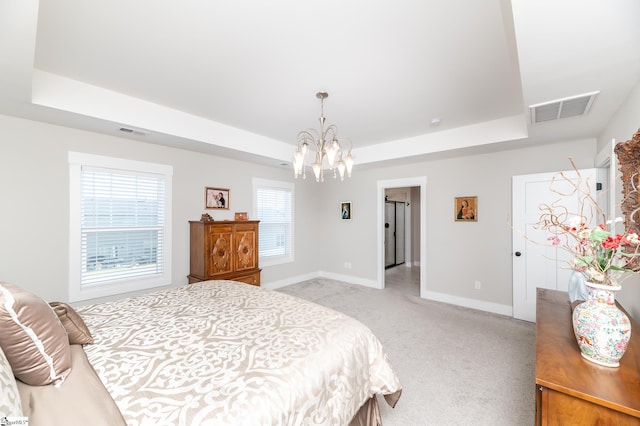 bedroom featuring a raised ceiling, light carpet, and visible vents