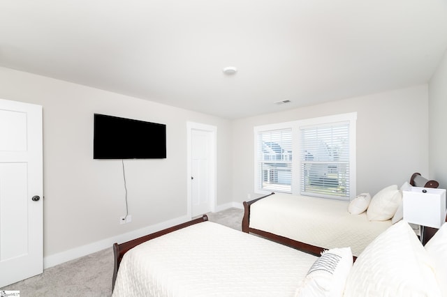 bedroom featuring light colored carpet and baseboards