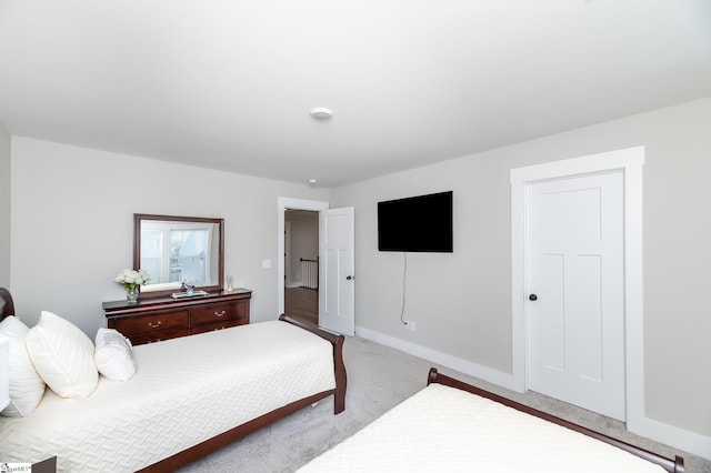 bedroom featuring light colored carpet and baseboards