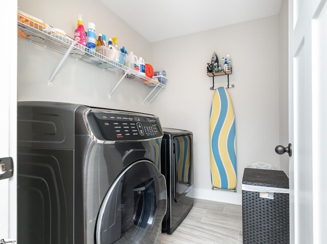 laundry area featuring laundry area, separate washer and dryer, and baseboards