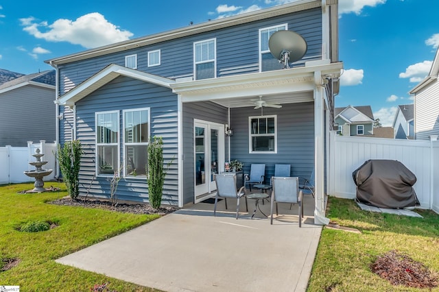 rear view of property with fence, a patio, a lawn, and a ceiling fan