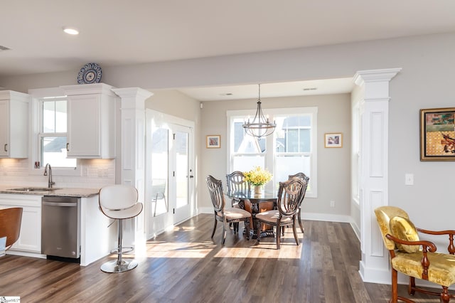 dining area with dark wood-type flooring, visible vents, baseboards, and decorative columns