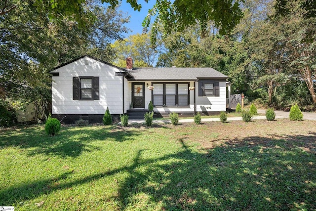 view of front of home with a front lawn, crawl space, and a chimney