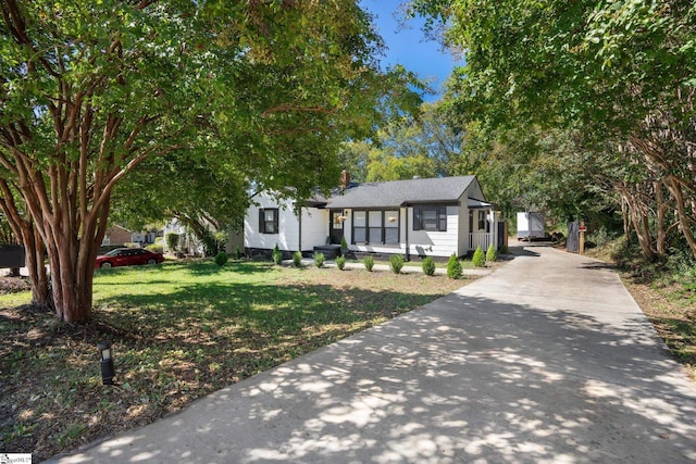 view of front of home featuring concrete driveway and a front lawn