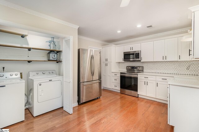 kitchen with stainless steel appliances, light wood-type flooring, visible vents, and washer and clothes dryer