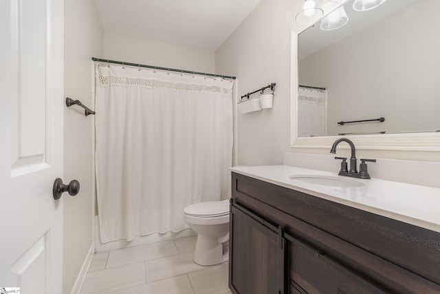 bathroom with toilet, vanity, and tile patterned flooring