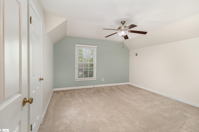 additional living space featuring ceiling fan, baseboards, light carpet, and lofted ceiling