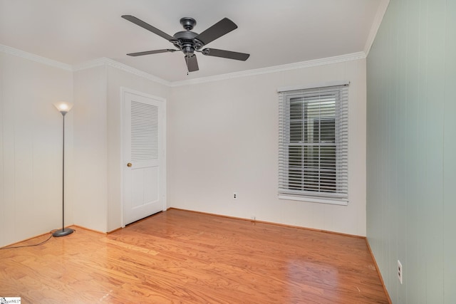 empty room with wood finished floors, ornamental molding, baseboards, and a ceiling fan