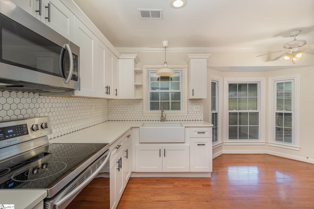 kitchen featuring visible vents, white cabinets, a sink, light countertops, and appliances with stainless steel finishes