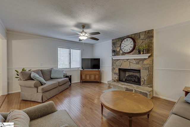 105 Berrywood Ct, Greer, SC 29650 - living room featuring hardwood / wood-style flooring, a textured ceiling, crown molding, ceiling fan, and a stone fireplace