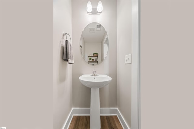 bathroom featuring wood finished floors, a sink, and baseboards