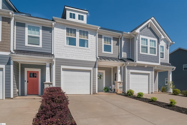 multi unit property with driveway, metal roof, and a garage