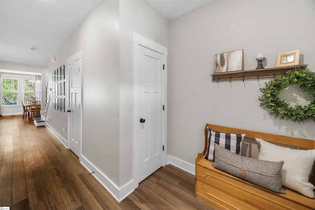 hallway featuring baseboards and wood finished floors