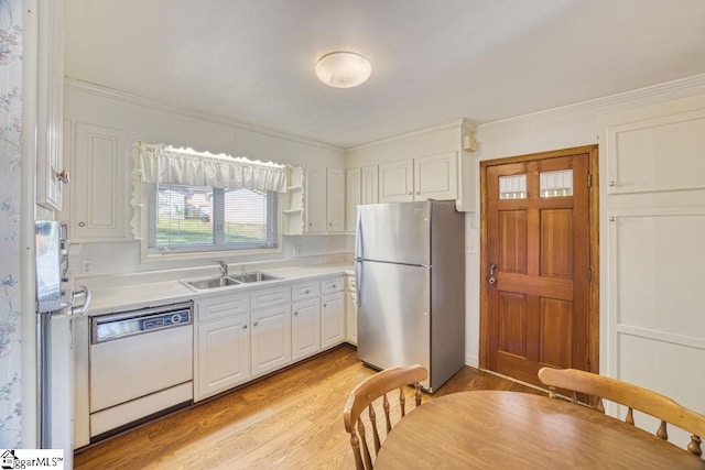 kitchen featuring light wood-style floors, freestanding refrigerator, dishwasher, light countertops, and a sink