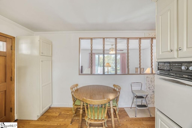 dining area with crown molding, light wood finished floors, and baseboards