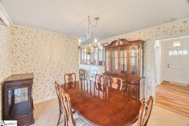 dining area featuring a chandelier, light wood-style floors, wallpapered walls, and ornamental molding