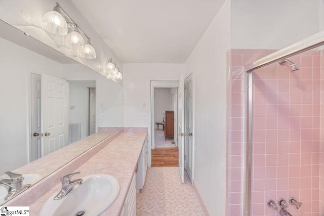 bathroom with vanity, visible vents, and walk in shower