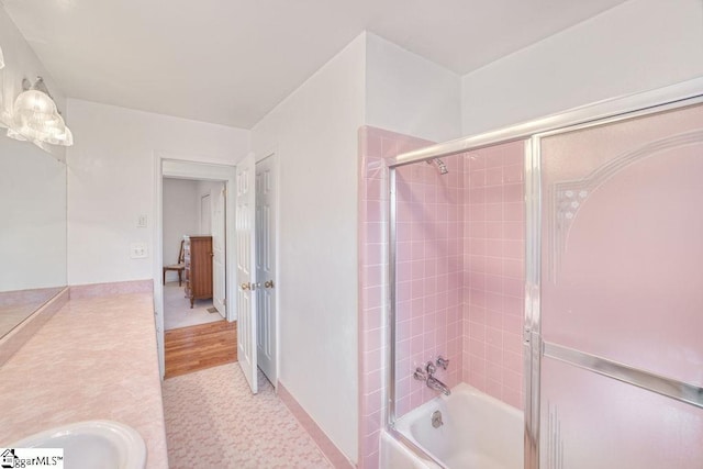 bathroom with baseboards and combined bath / shower with glass door