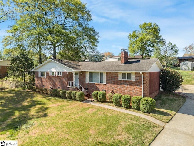 single story home featuring brick siding, a front lawn, and a chimney