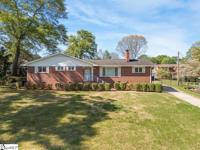 ranch-style home featuring brick siding, a front yard, and a chimney