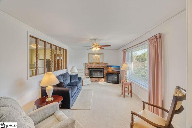 living area featuring crown molding, ceiling fan, a fireplace, carpet, and baseboards