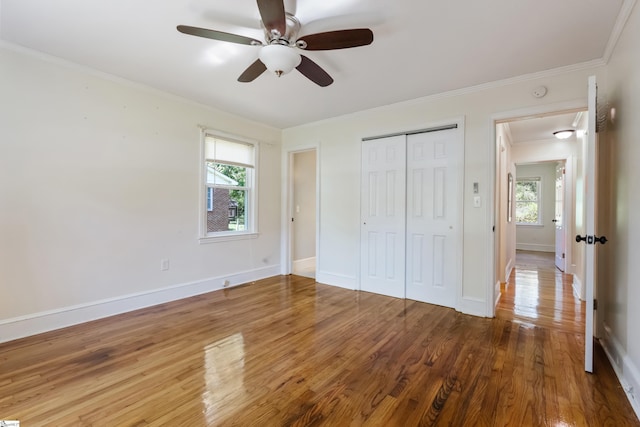 105 Pinewood Ave, Clinton, SC 29325 - unfurnished bedroom featuring crown molding, wood finished floors, a closet, and multiple windows