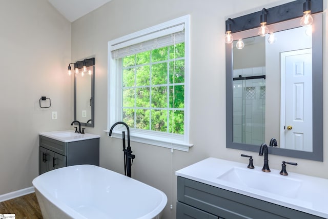 bathroom featuring a tile shower, a soaking tub, wood finished floors, and a sink