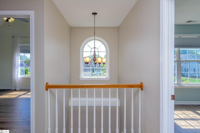 interior details featuring visible vents, baseboards, a chandelier, and wood finished floors