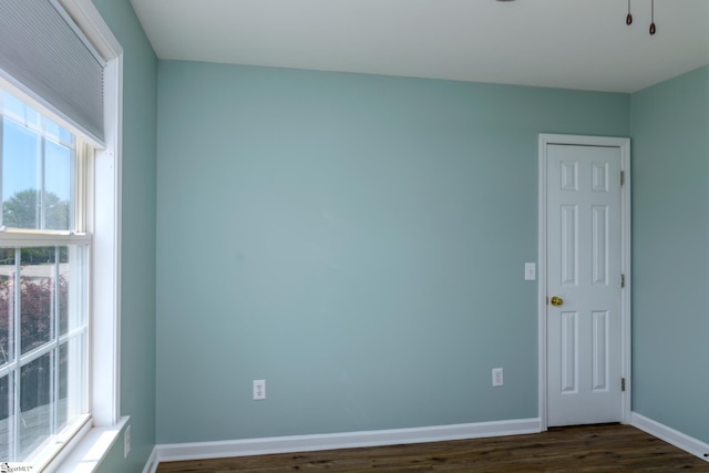 spare room with dark wood-style floors and baseboards