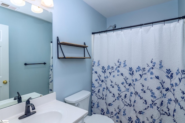 bathroom featuring visible vents, toilet, a shower with shower curtain, and vanity