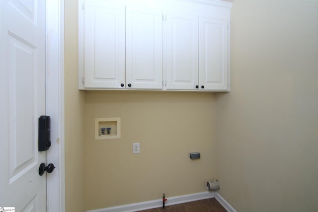laundry room featuring baseboards, washer hookup, and cabinet space