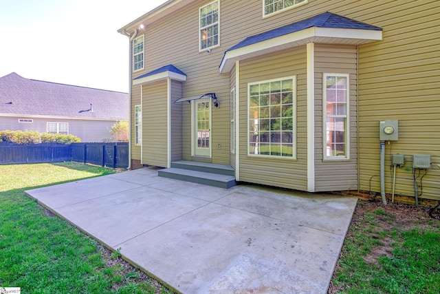 rear view of house featuring a patio area, fence, and a lawn