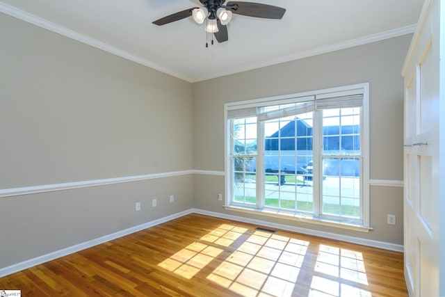 unfurnished room featuring ceiling fan, visible vents, baseboards, and wood finished floors