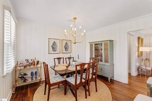 dining space with a chandelier, wood finished floors, baseboards, and ornamental molding