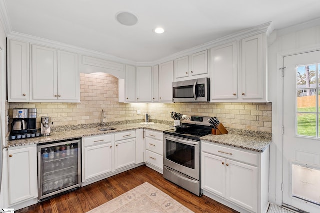 kitchen featuring tasteful backsplash, dark wood finished floors, stainless steel appliances, beverage cooler, and a sink