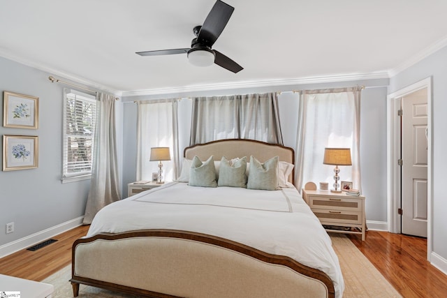 bedroom with baseboards, light wood-type flooring, crown molding, and visible vents