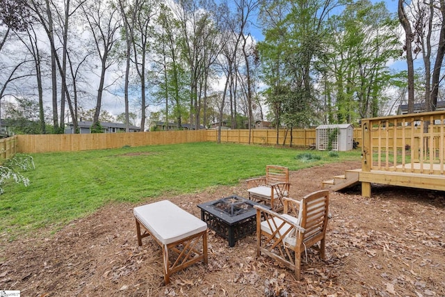 view of yard with a shed, a fire pit, an outdoor structure, and fence