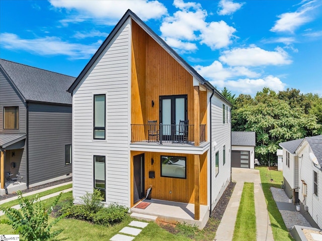 view of front of house featuring french doors, a garage, and a balcony