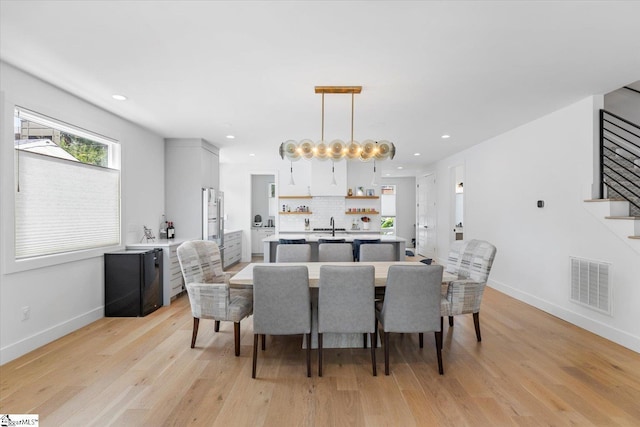 dining room featuring stairway, visible vents, baseboards, and light wood-style flooring