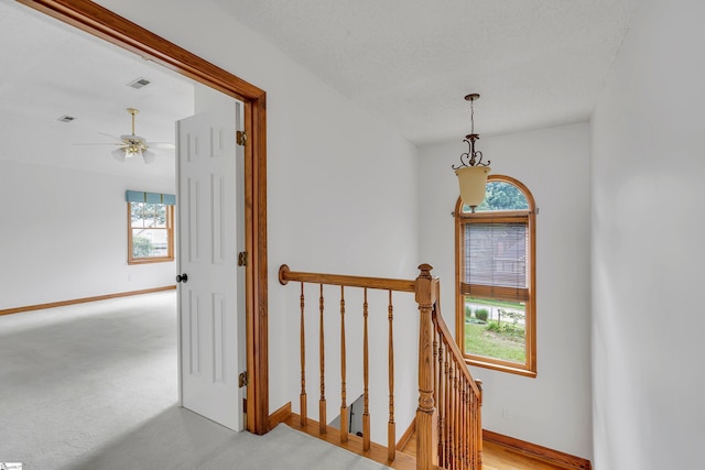 stairs with visible vents, baseboards, ceiling fan, and carpet