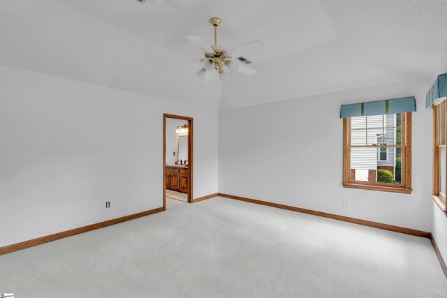 unfurnished room featuring visible vents, baseboards, a ceiling fan, vaulted ceiling, and carpet flooring