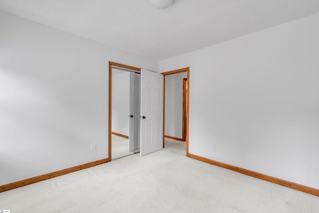 empty room with baseboards, carpet flooring, and a textured ceiling