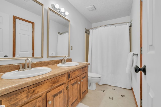 bathroom featuring toilet, a textured ceiling, a sink, and visible vents
